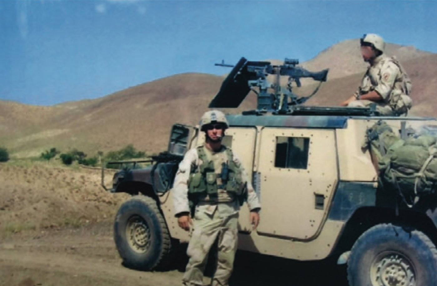 Soldiers on patrol with a Humvee in mountainous terrain